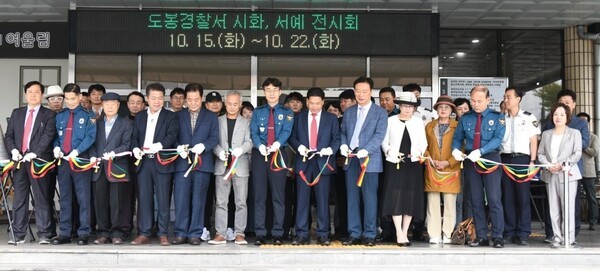 ▲정한규 도봉경찰서장(중앙)이 ‘제79주년 경찰의 날’을 기념해 한휘준 도봉문인협회장(우 7)과 문인들이 도봉경찰서 정문 앞에서 시·서예 전시회 개막 커팅식에 기념촬영을 하고 있다.