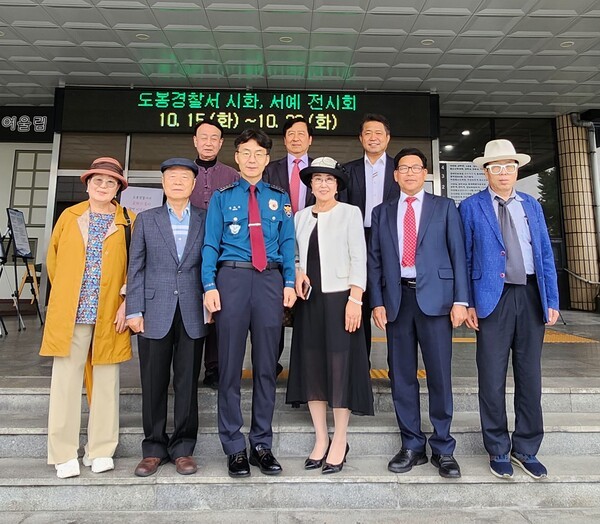 ▲정한규 도봉경찰서장(좌측 3)이 ‘제79주년 경찰의 날’을 기념해 한휘준 도봉문인협회장(우 2)과 문인들이 도봉경찰서 정문 앞에서 시·서예 전시회에 참석해 기념촬영을 하고 있다.