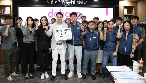 ▴오언석 도봉구청장(좌 4)과 김태환 도봉구지부장(우 4)이 ‘2024 노사협의회 협약식’을 마치고 조합원들과 함께 파이팅을 외치고 있다.