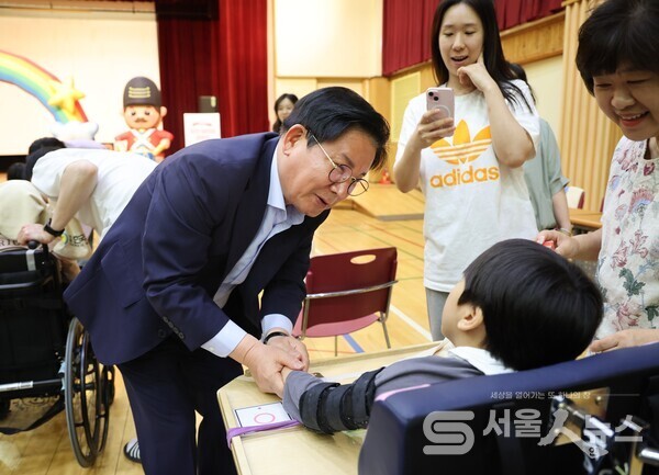 ▲박강수 마포구청장이 한국우진학교에서 아동과 인사하고 있는 모습.