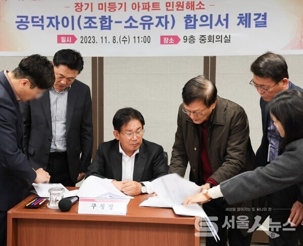 ▲박강수 마포구청장이 마포구청 중회의실에서 공덕자이아파트 숙원사업인  등기를 위한 합의서에 서류를 체크하고 있는 모습.