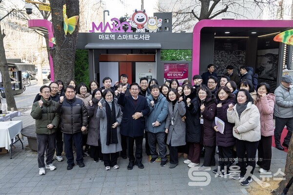 ▲마포구 스마트도서관 앞에서 박강수 마포구청장이 참석한 내외빈과 기념촬영을 하고 있다.