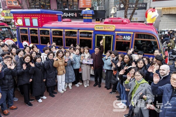 ▲박강수 마포구청장(중앙)이 마포 순환열차버스 앞에서 환하게 손을 들어보이고 있다.