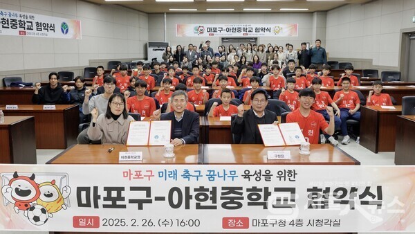 ▲박강수 마포구청장(우 2)이  아현중학교 업무협약식에서 축구부와  기념사진을 촬영하고 있다.