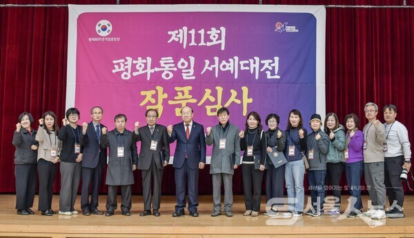 ▴김윤수 도봉구협의회장(좌 7)과 이정호 운영위원장(좌 4)이 작품심사에 앞서 심사위원, 추진위원들과 함께 파이팅을 외치며 단체사진 촬영을 하고 있다.(사진제공=정나연 사진작가)