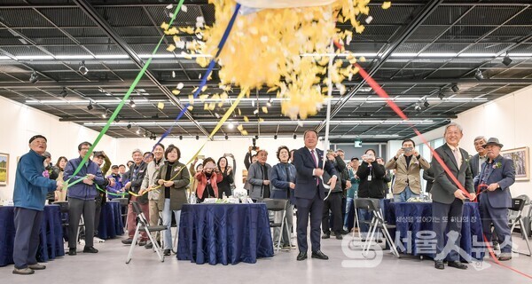 ▲이천우 지부장(앞줄 우 1)과 하객들이 ‘제3회 회원사진전시회’ 개막식 행사에서 오색 리본을 당기며, 개전함을 열고 있다.(사진 제공=정나연 사진작가)