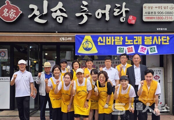 ▲박성규 회장(두번째 줄 우측 3)과 ‘신바람노래봉사단’ 임원들이 일일찻집 앞에서 파이팅을 외치며 기념사진을 촬영하는 모습.