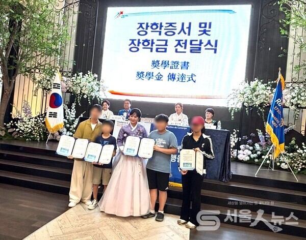 ▲화홍로타리클럽 이·취임식에서 보호대상자 가정 자녀들에게 장학금을 전달하고 있다.