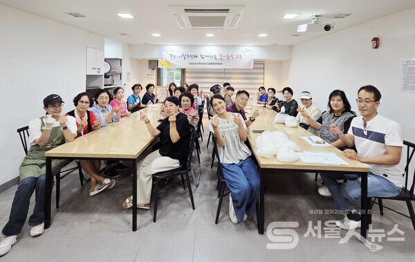 ▴송기정 도봉2동 주민자치회장(두 번째 줄 우1)이 ‘북한이탈주민과 함께하는 절기음식 교류’행사를 마치고 자치위원들과 함께 기념사진을 찍고 있다.