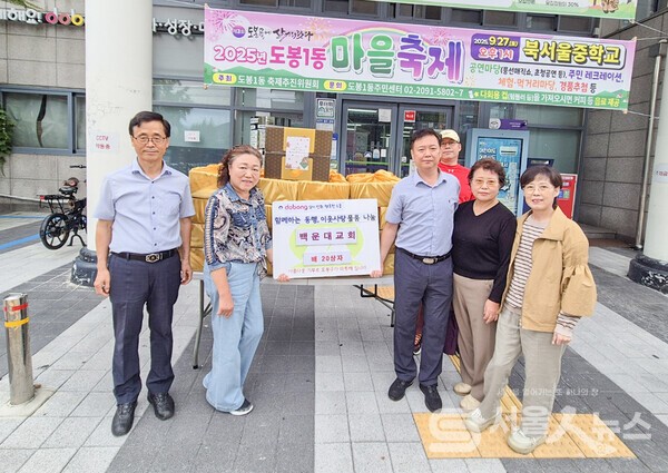 ▴배 20상자를 기탁한 백운대교회 백의현 담임목사(좌 1)와 이광재 도봉1동장(우 3)이 관계자들과 함께 기념사진을 찍고 있다.