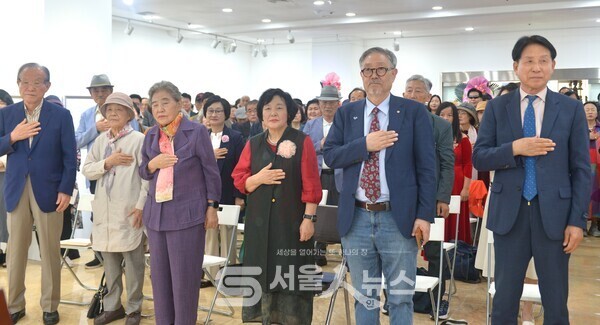 ▲김민정 시인(우측 3)이 김호운 한국문인협회 이사장(우측 2)과 내빈들이 함께 국민의례를 하는 모습.