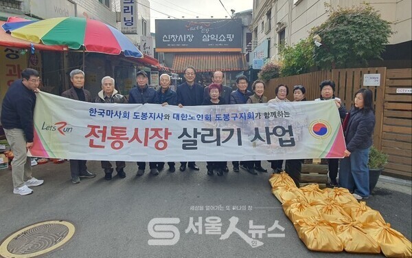 ▴한국마사회와 대한노인회 도봉구지회 심형섭 회장(뒷쪽 중앙)이 ‘전통시장 살리기’ 행사를 진행한 후, 기념사진을 촬영하는 모습.